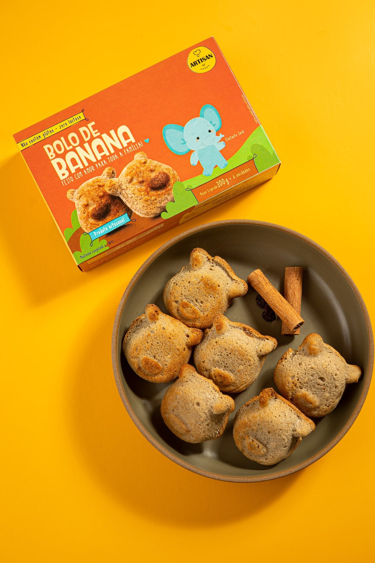 Caixa de bolo de banana sem açúcar ao lado do prato com os bolinhos