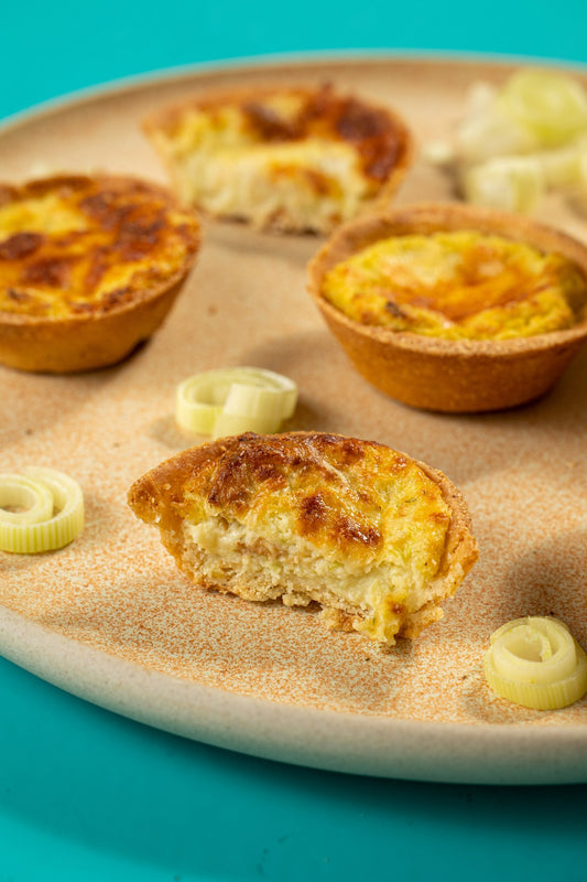 Empada de queijo cortada, em close, mostrando o recheio de queijo e alho-poró