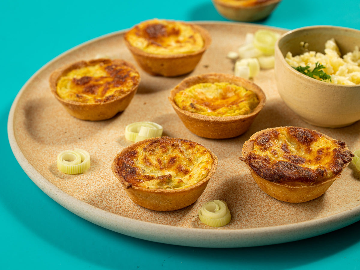 Por dentro: empada de queijo partida ao meio, com o recheio derretido à mostra