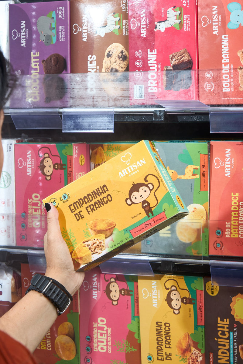 Mão pegando um produto Artisan na gôndola do freezer de uma loja