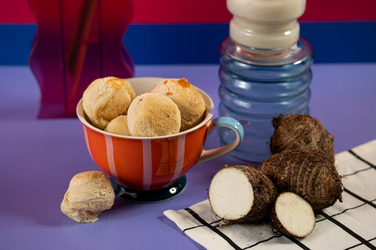 Pães de queijo de inhame na mesa, com xícara de café e inhame ao lado