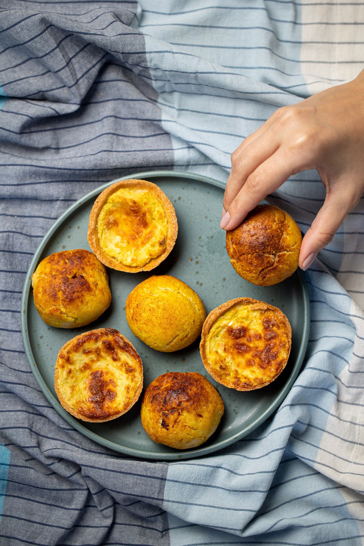 Pãezinhos de batata doce com frango em travessa sobre tecido, na mesa