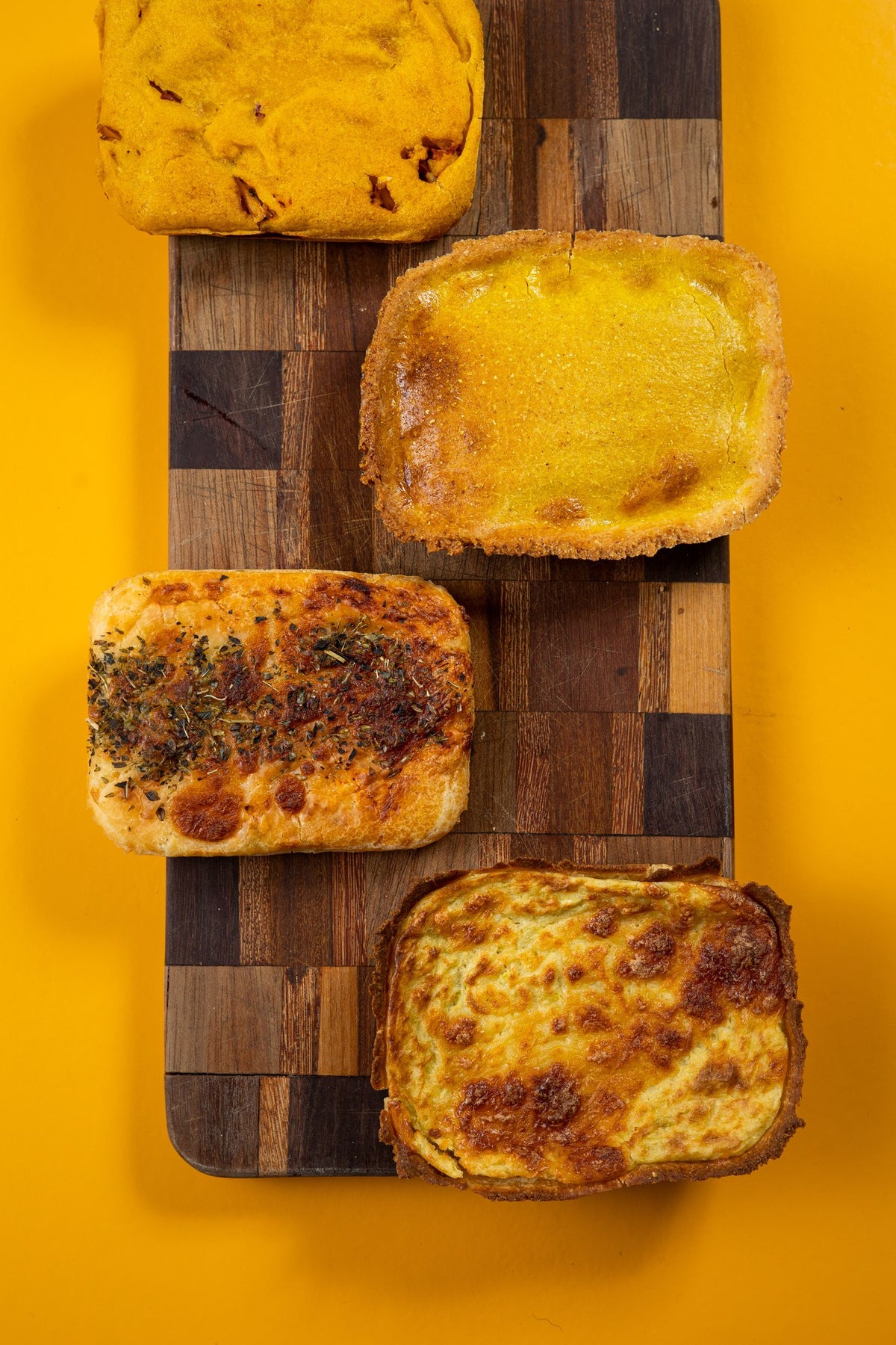 Quiche de queijo com alho-poró sobre tábua, fundo amarelo