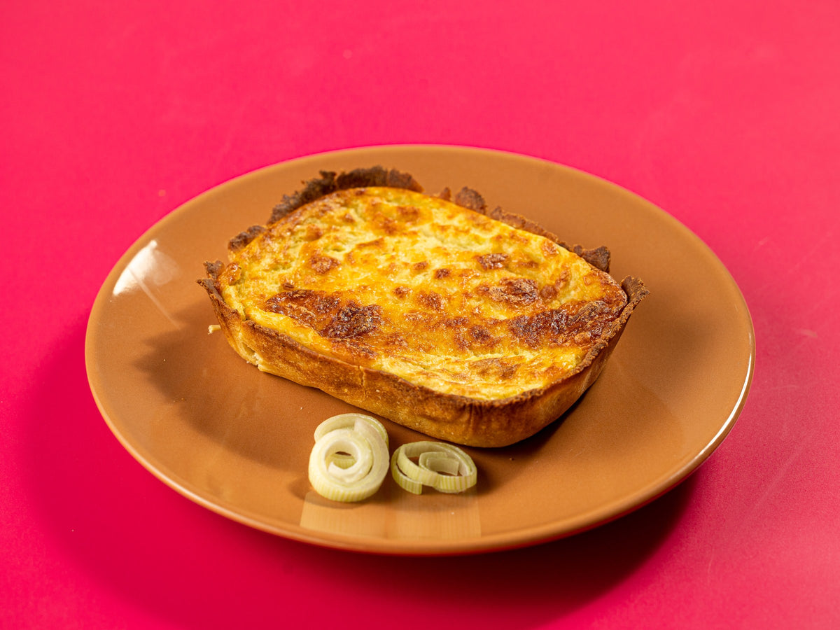 Por dentro: quiche de queijo partida ao meio no prato, com o recheio à mostra